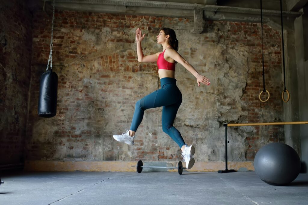 HIIT WORKOUTS - 3 DIFFERENT WORKOUTS GUARANTEED TO GET THE BLOOD PUMPING 1 Sporty woman during HIIT workout. Sportswoman jumping high in the process of training in the gym