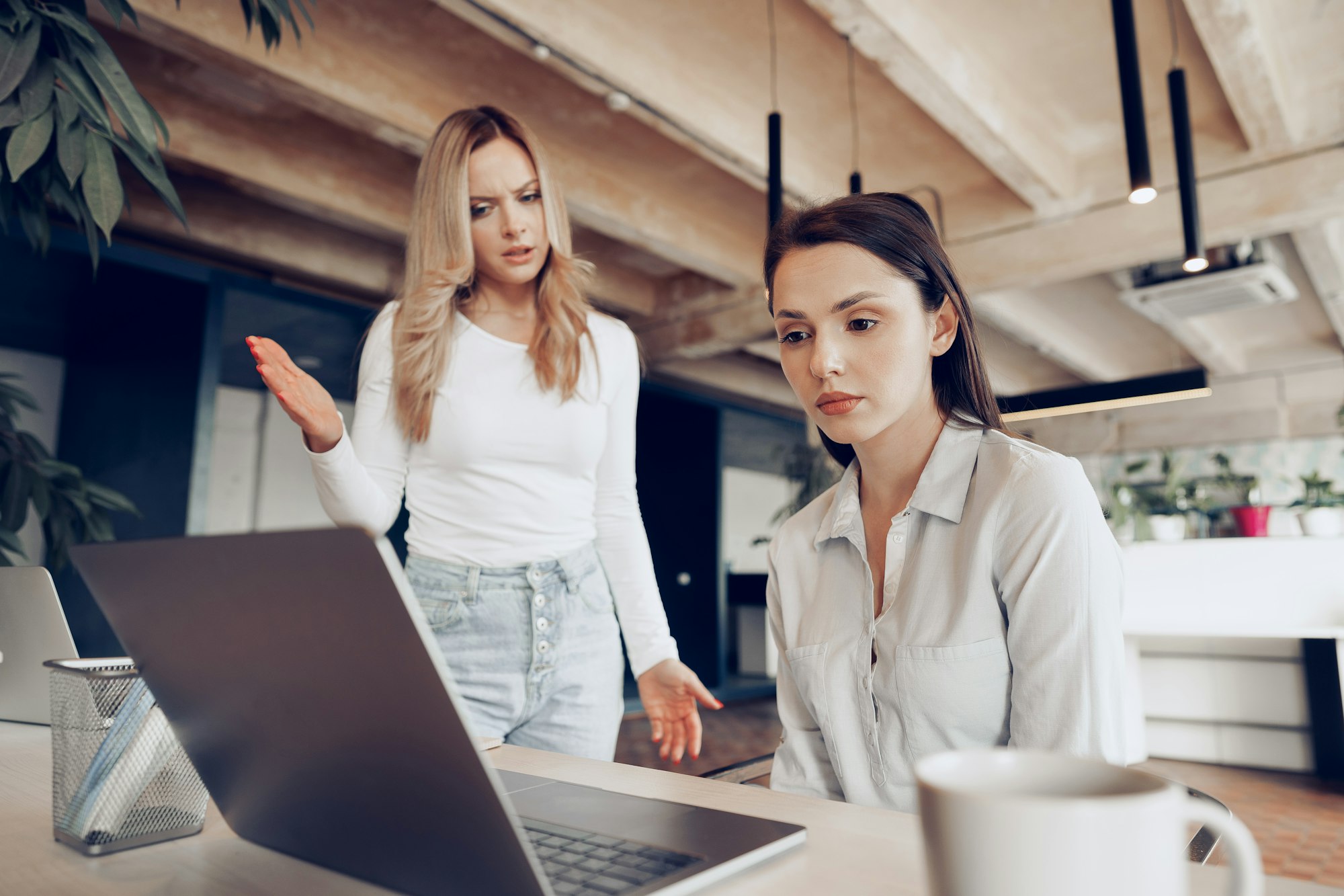 Young female boss scolding her female subordinate for bad work results